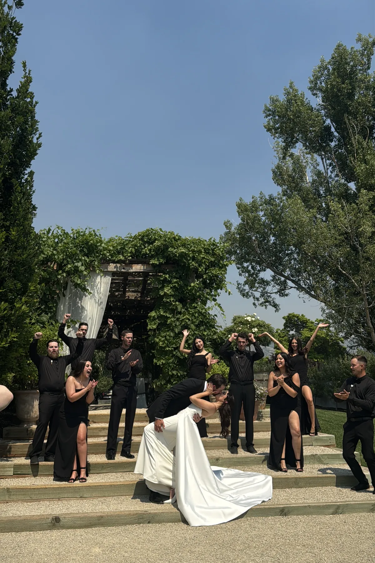 Wedding party cheering and celebrating on the venue steps.