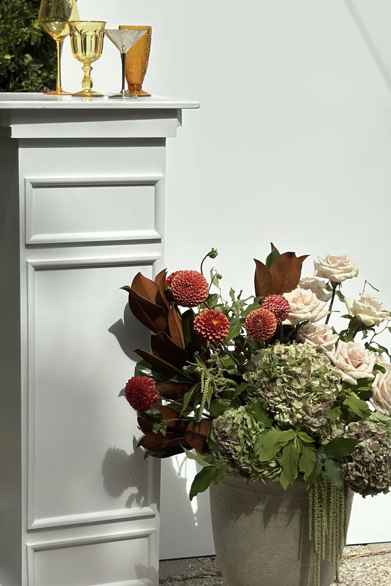 Rust dahlias and cream roses in a wedding arrangement.