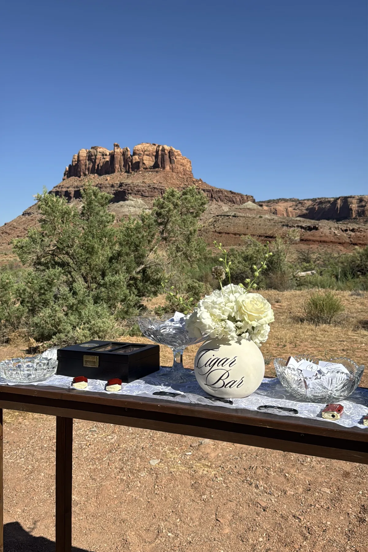 Cigar bar table with white florals set against Moab red rock.